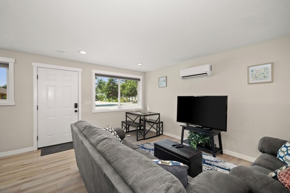 A living room with a sofa, TV, and a small table.
