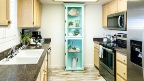 A kitchen with a central island, a sink, a microwave, and a refrigerator.