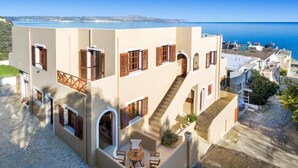 Un immeuble à plusieurs étages doté d’une cour intérieure, d’un escalier et offrant une vue sur la mer.