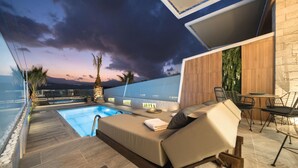 A modern outdoor pool area with a lounge chair, a table, and chairs.