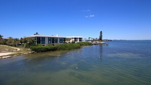 A waterfront property with a large building, a dock, and a clear view of the water. - Anna Maria Island Bridge Port Beach Resort (Bradenton Beach)