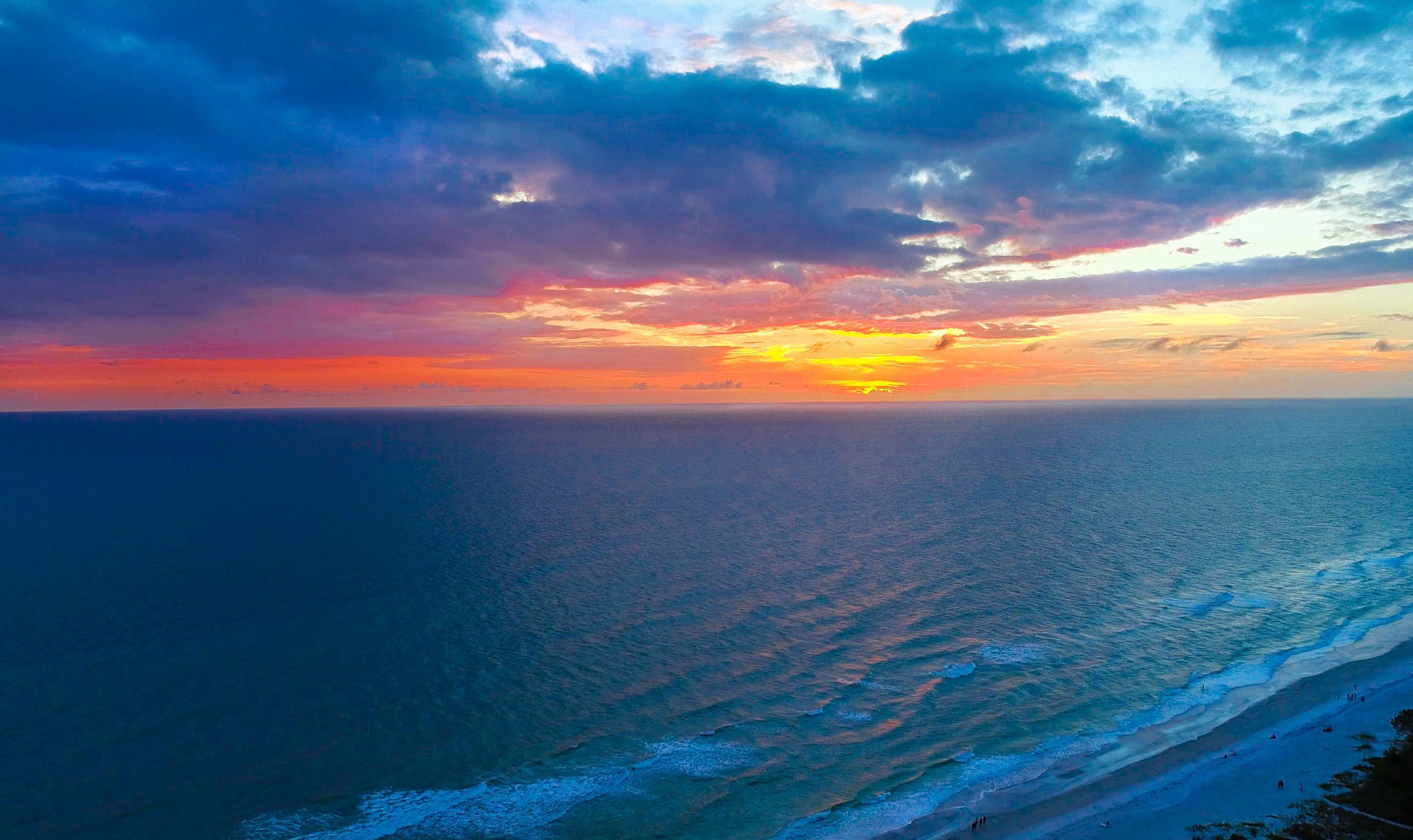 Une plage avec des vagues et un coucher de soleil.