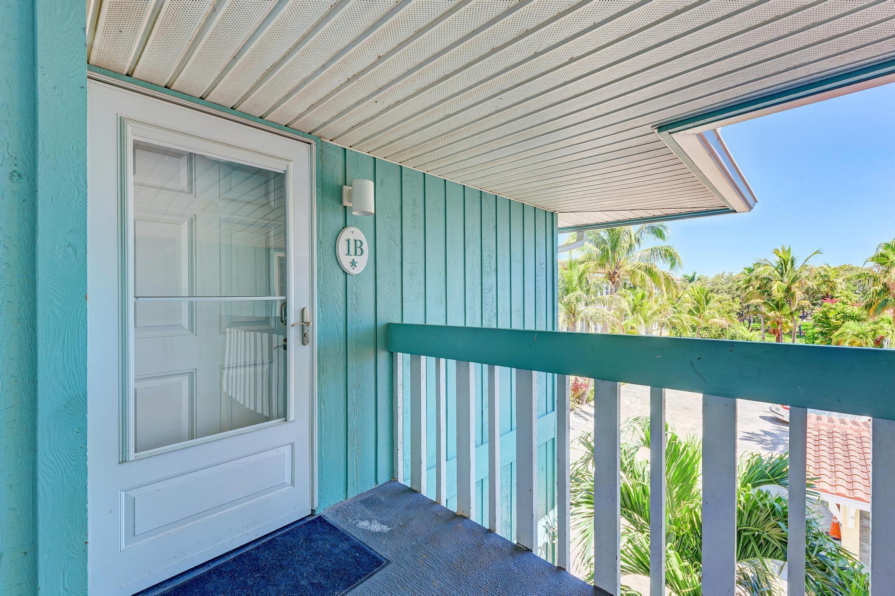 A turquoise door with a glass panel and a mailbox.