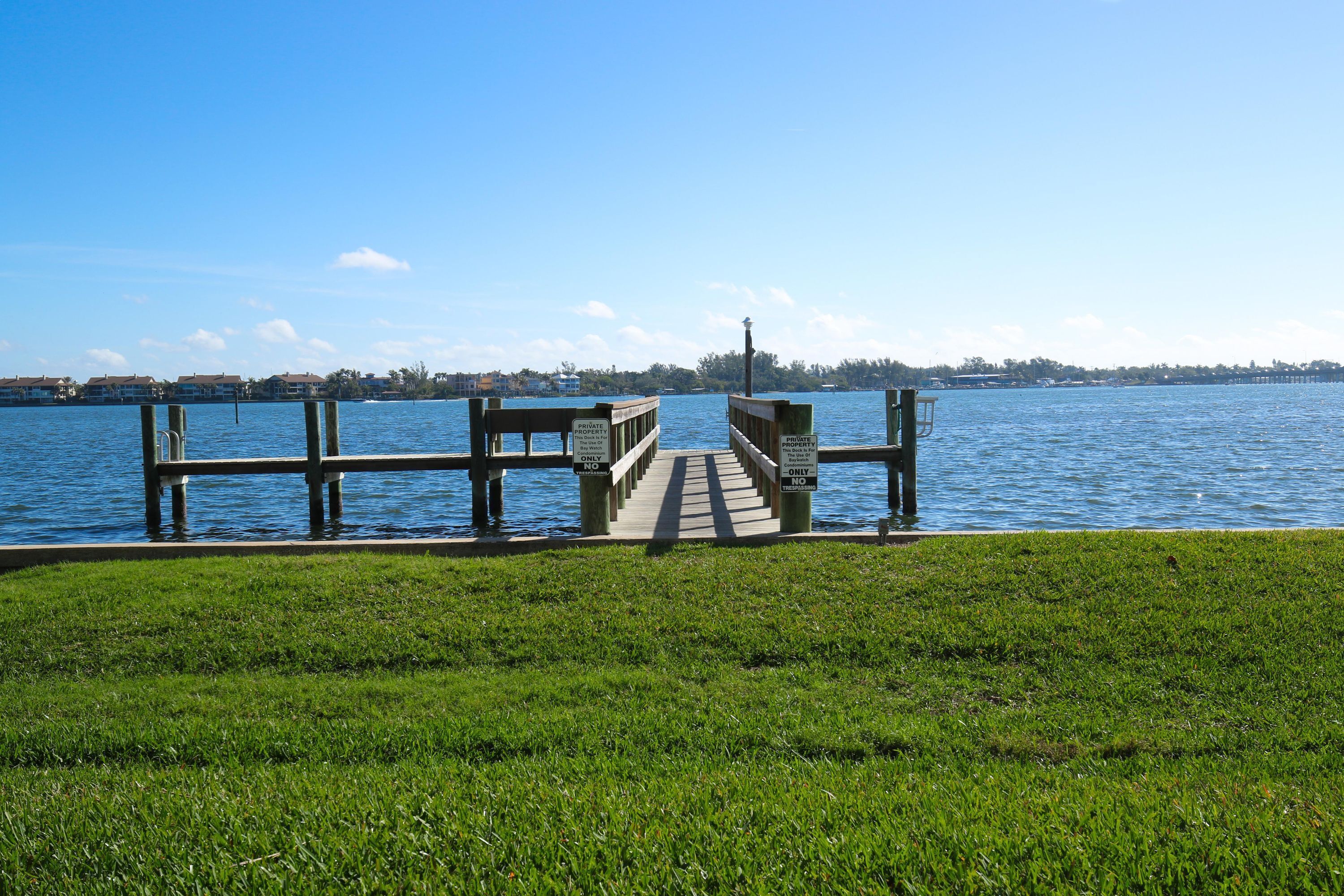 A wooden pier extending into a body of water with a clear sky above.