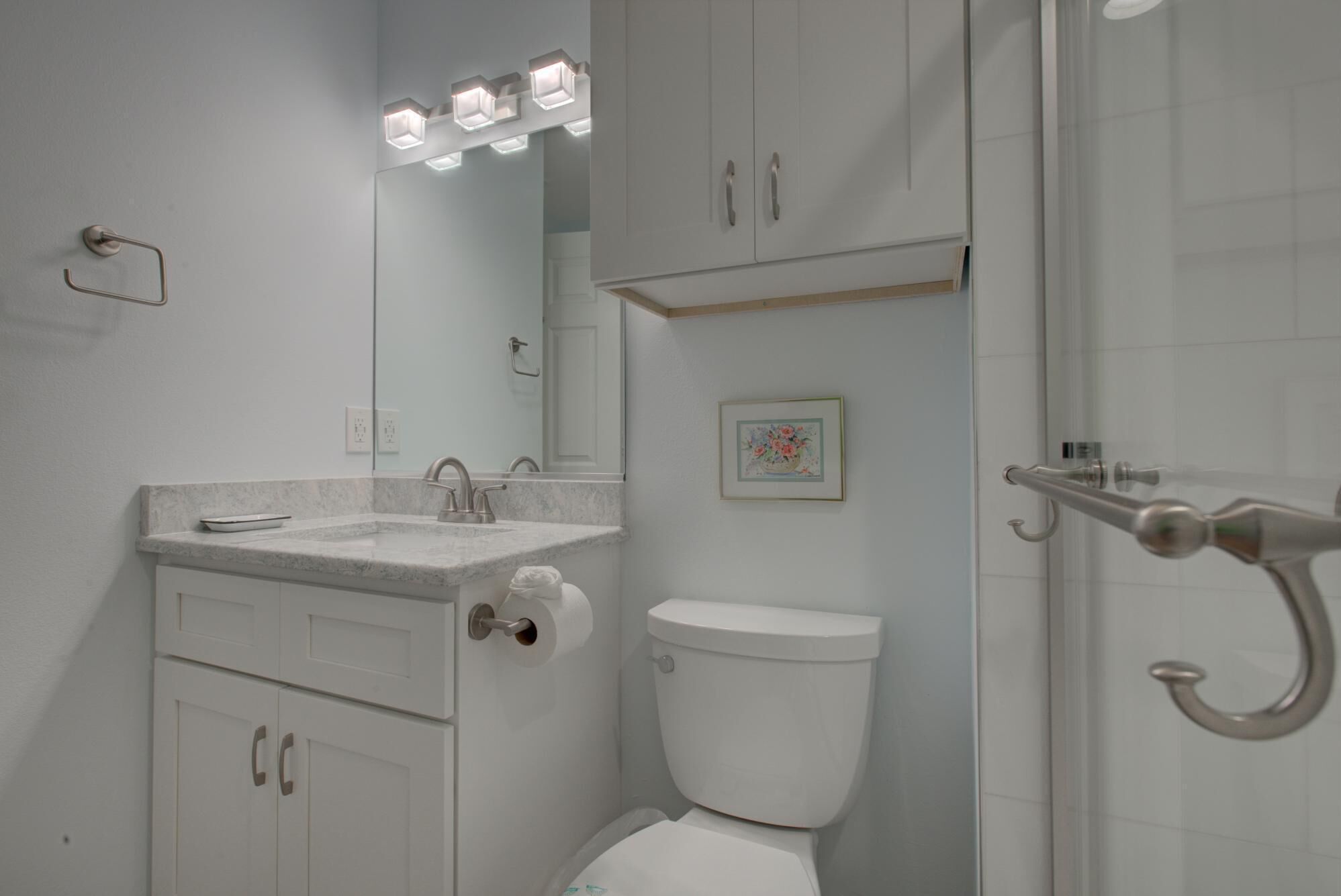 A bathroom with a toilet, sink, and shower.