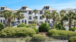 A row of white villas with flat roofs, surrounded by palm trees and well-maintained hedges. - Modern 2br/2ba, Pet friendly, steps to private beach access and restaurants! (Miramar Beach)