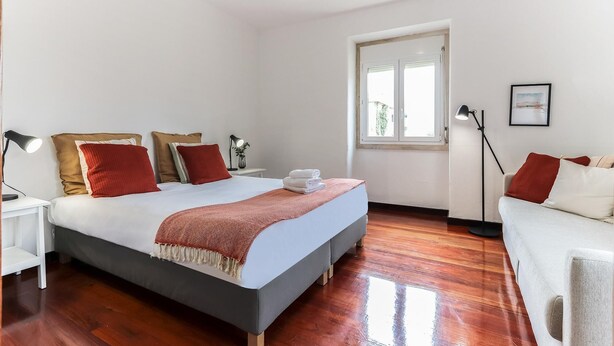 A bedroom with a bed, bedside tables, a nightstand, a window, and a floor lamp. - Belem Boutique IV by Homing (Lisbon)