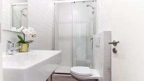 A bathroom with a white sink, toilet, and shower. - Belem Boutique IV by Homing (Lisbon)