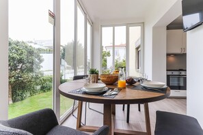A modern dining area with a round table, chairs, and a view of a garden. - Belem Boutique VI by Homing (Lisbon)