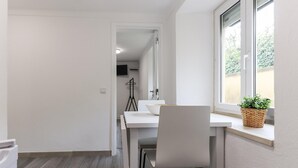 A modern kitchen with a white countertop, a bowl, and a chair.