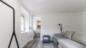 A modern living room with a sofa, a small side table, and a tripod stand.