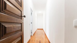 A hallway with wooden flooring and white walls. - Belem Boutique IX by Homing (Lisbon)