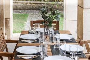 A dining table set with plates, glasses, and cutlery, surrounded by chairs. - Belem Boutique II by Homing (Lisbon)