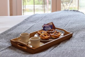 A tray with pastries and two cups on a bed with a gray blanket. - Belem Boutique Viii by Homing (Lisbon)