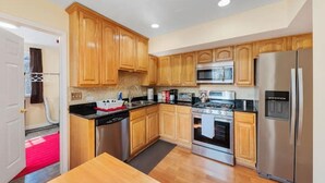 A modern kitchen with wooden cabinets, stainless steel appliances, and a central island. - PROMO 15% MONTHLY DISCOUNT!
Cozy House, Close to Benedictine & North Central (Lisle)