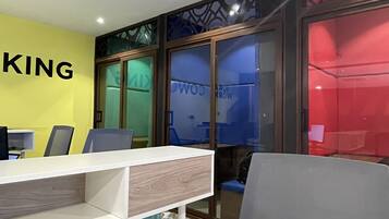 Un espacio de oficina moderno con una pared amarilla, un escritorio blanco y una silla gris.