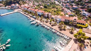 An aerial view of a coastal town with houses, a marina, and a clear blue sea. - Guesthouse Aurora - Double Room with Sea View - 3 (Trpanj)