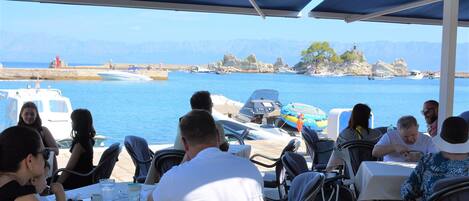 Un restaurante frente al mar, con terraza y vistas a la costa rocosa.