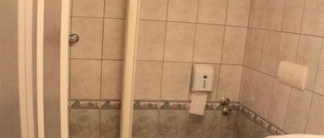 A bathroom with a shower, toilet, and sink.
