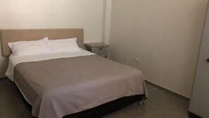 Enjoy a restful stay in this cozy room featuring a single bed and a nightstand.