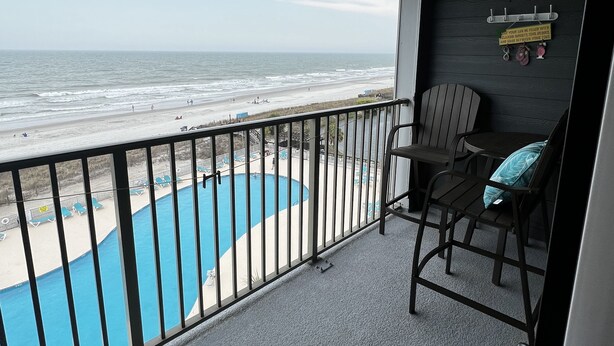Ein Balkon mit Blick auf Strand und Pool.