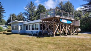 A house with a deck and a boat. - Betty's Beach House Bungalow (Brookings)