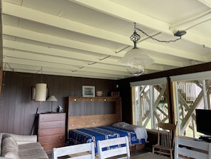 Um quarto acolhedor com uma cama de madeira, uma cômoda e uma televisão.