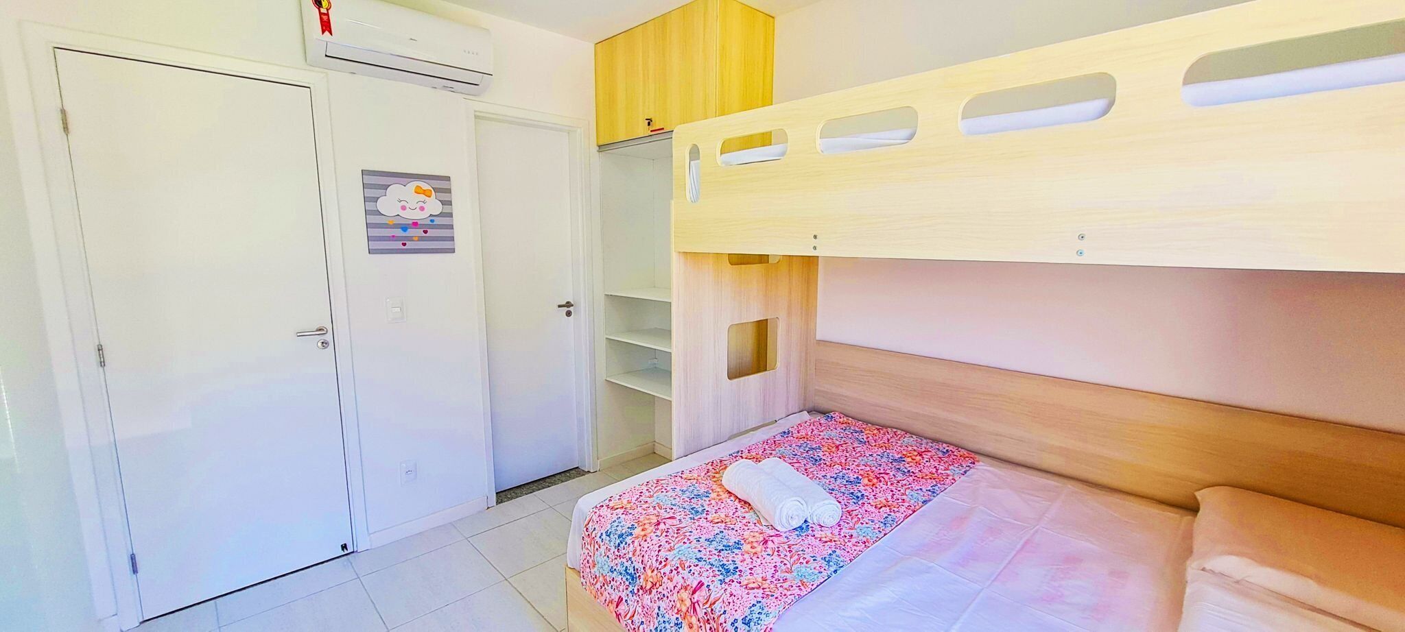 A bedroom with a bunk bed, a wardrobe, and a small closet.