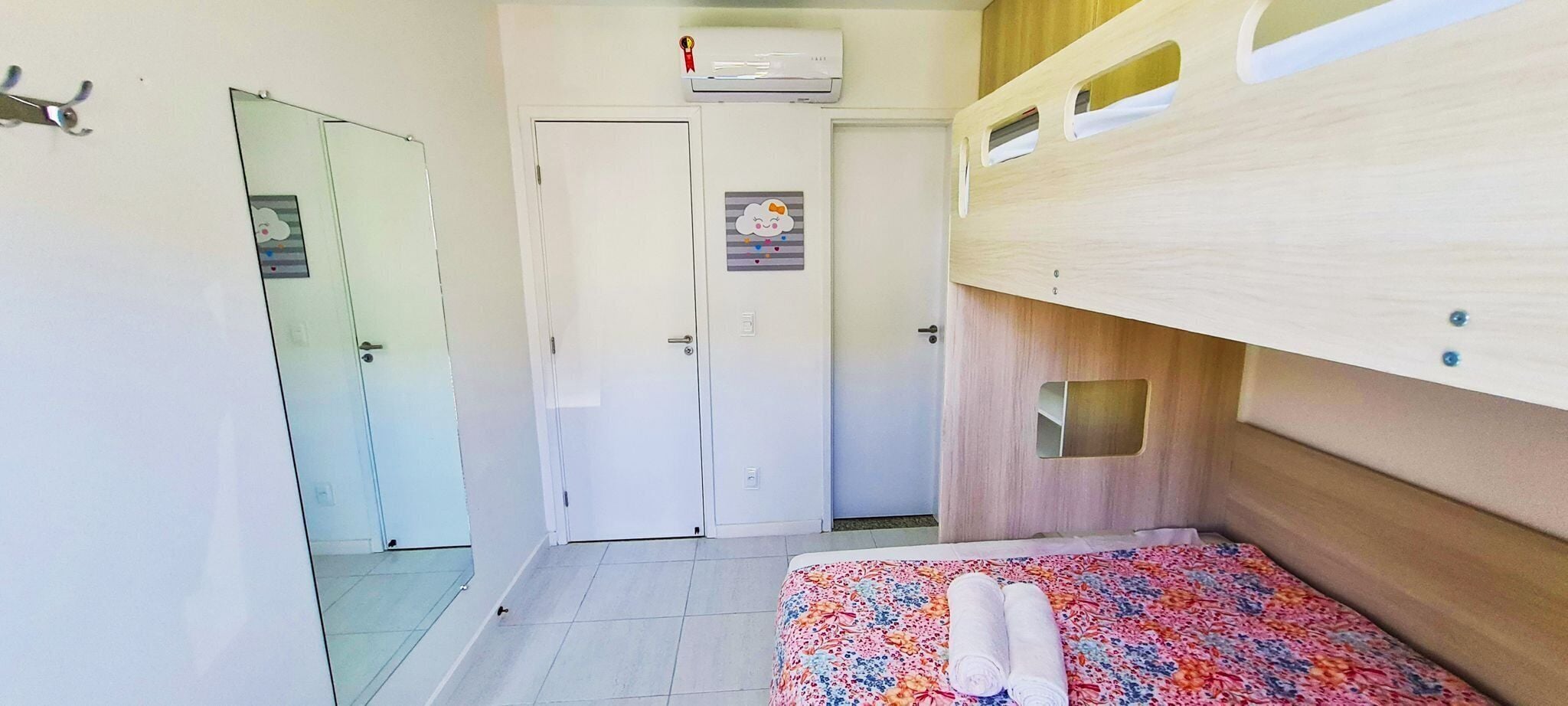 A small, compact room with a bunk bed, a single door, and a small window.