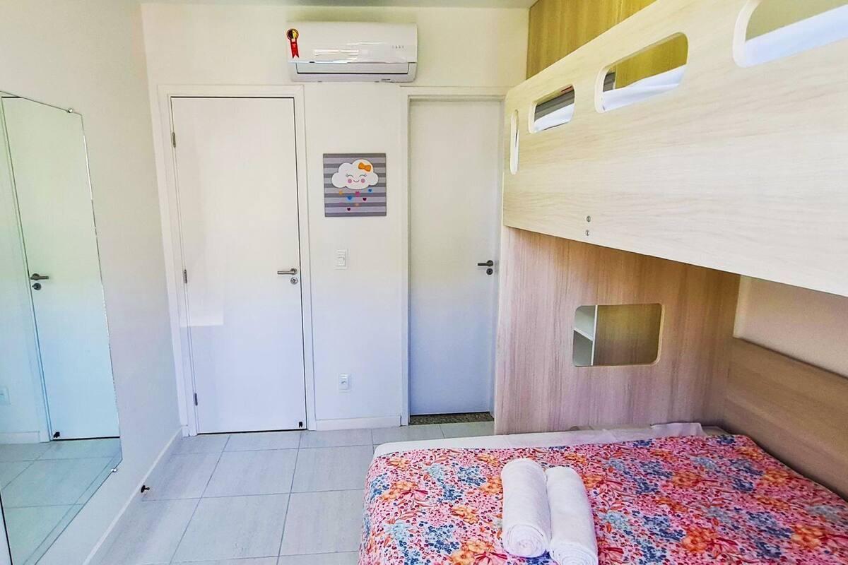 A small, compact room with a bunk bed, a single door, and a small window.