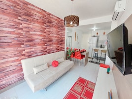 A modern living room with a sofa, dining table, and TV.
