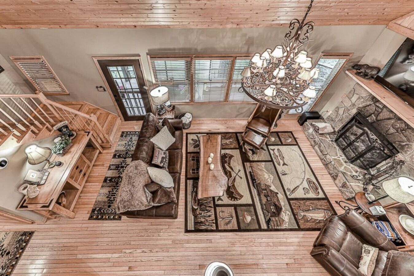 A spacious living room with a large sofa, a fireplace, and a chandelier.