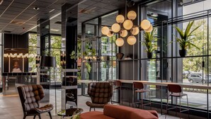 A modern lobby with a seating area, large windows, and indoor plants. - Radisson RED Oslo Økern (Oslo)