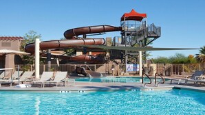 A pool with water slides and a lifeguard tower.