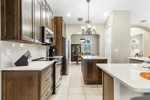 Enjoy cooking in this well-lit kitchen with a central island, sink, and stainless steel appliances.