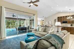 Relax in a spacious living area with a sliding glass door leading to a poolside patio.