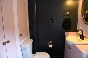Ein Badezimmer mit Toilette, Waschbecken und Spiegel.