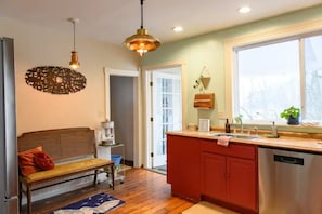 A kitchen with wooden flooring, a built-in island, and a red cabinet. - Vintage Charmer Waterfall views! sleeps 5! (Ithaca)