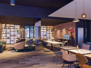 A modern library with bookshelves, seating areas, and a brick wall. - ibis Styles Saint Nazaire Centre Gare (Saint-Nazaire)