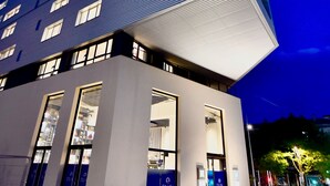 Un hotel moderno con tejado plano, varios pisos y amplias ventanas.