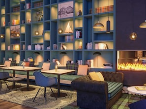 A cozy library with bookshelves, seating, and a fireplace. - ibis Styles Saint Nazaire Centre Gare (Saint-Nazaire)