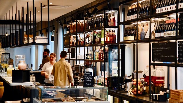 Un bar con estantes llenos de botellas y una pizarra de menú.