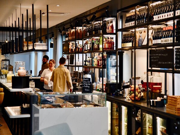 A bar with shelves of bottles and a menu board.
