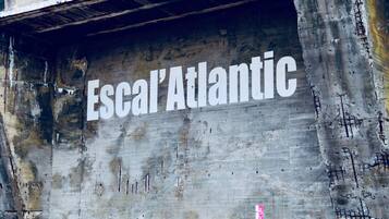 A concrete wall with graffiti reading "Escal'Atlantic" and a no parking sign.