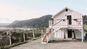 Un edificio blanco con balcón y escalera que conduce a la entrada.