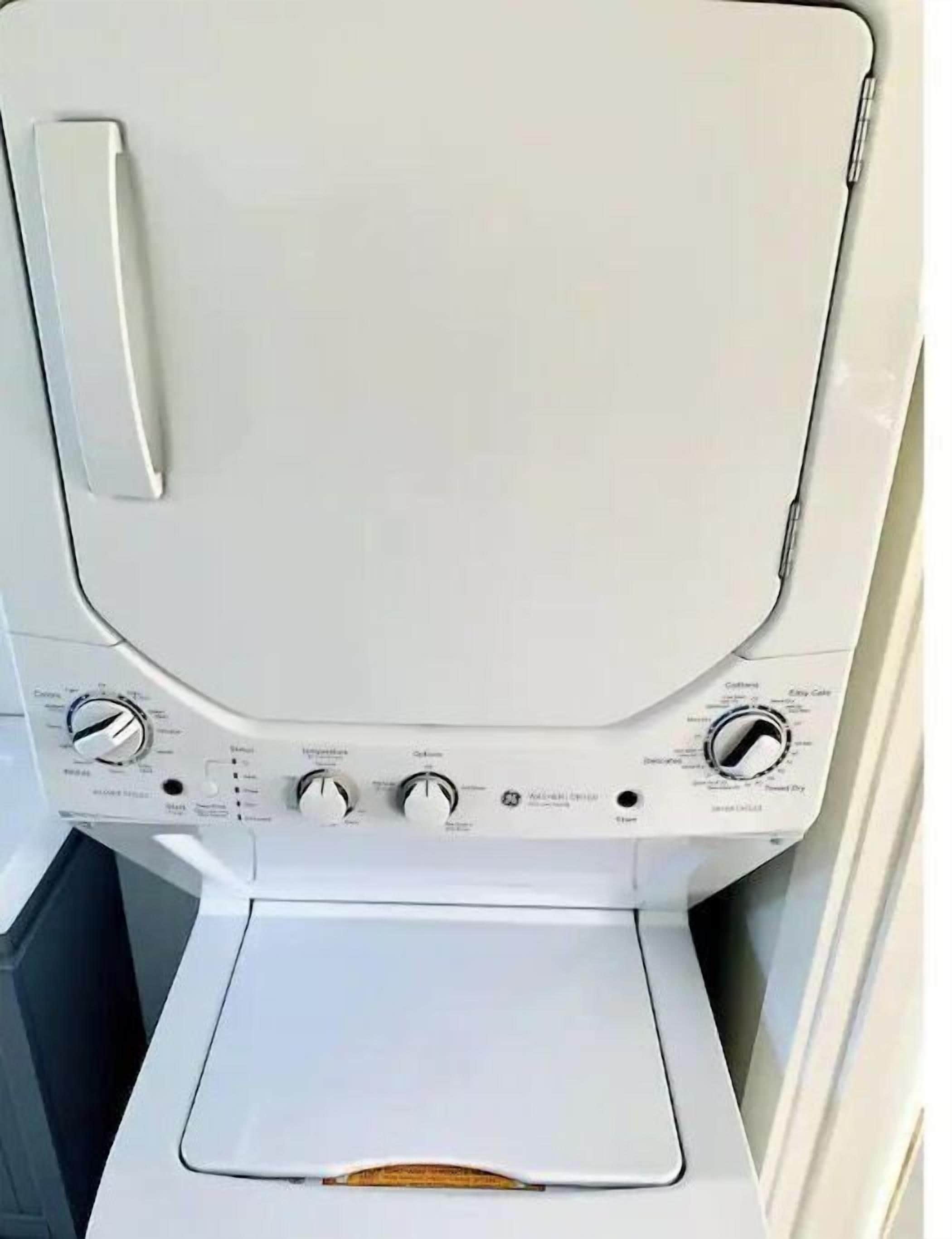 A front view of a washing machine with control knobs and a door handle.