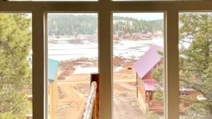 A room with a large window offering a view of a construction site and trees.