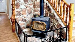 A stone wall with a wood-burning stove in a hallway.