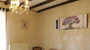 Ein Wohnzimmer mit einer Couch, einem Holztisch, einer Deckenleuchte und einer Heizung.