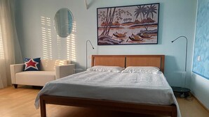 A bedroom with a large bed, a sofa, a painting, and a window with blinds. - Under The Moon: House in the Countryside Family Apartment with Balcony and Garden (Castel Bolognese)